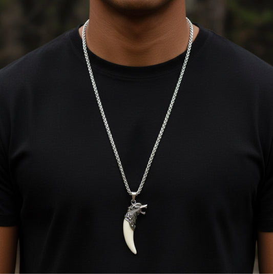 A model in a black T-shirt wearing a silver chain necklace with an ornate wolf-head pendant and cream fang charm.